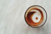 Glas mit Milchschaum in Form des Yin/Yang-Zeichens von oben gesehen Glas mit Milchschaum in Form des Yin/Yang-Zeichens von oben gesehen